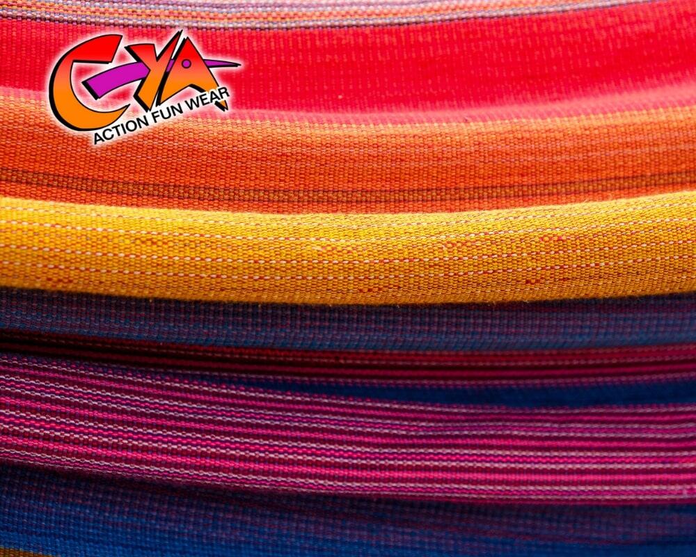 Colorful, striped fabric stacked in horizontal layers with the "CYA Action Fun Wear" logo in the top left corner.